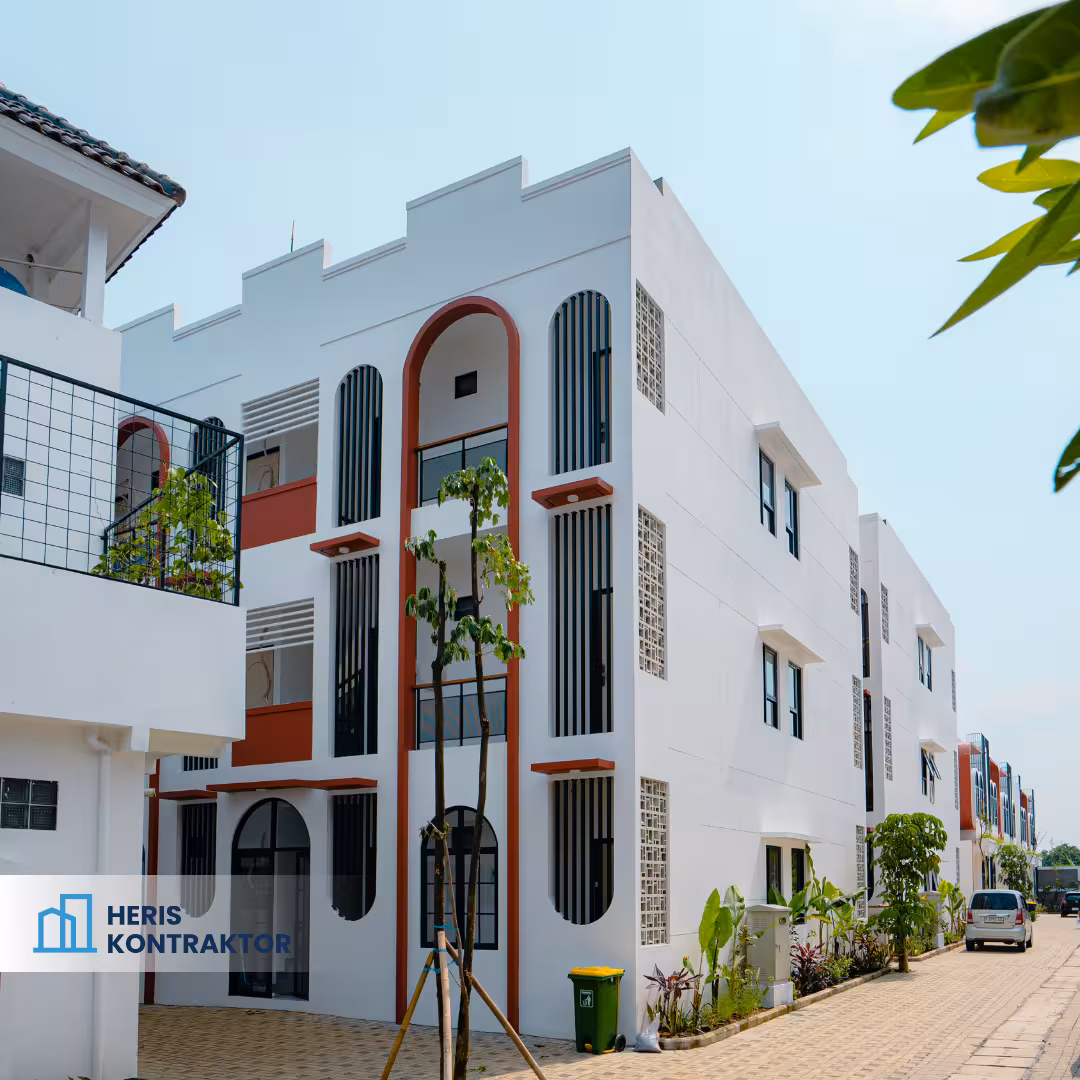 Bangunan kost modern tiga lantai di Bogor dengan fasad putih, aksen merah bata, dan jendela berjajar rapi.