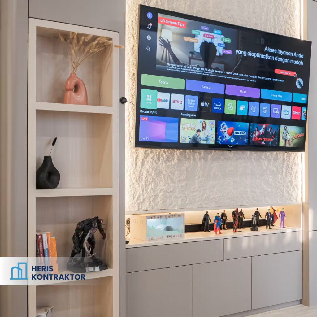 Rak pajangan vertikal di samping backdrop TV dengan dekorasi vas, buku, dan figur koleksi.