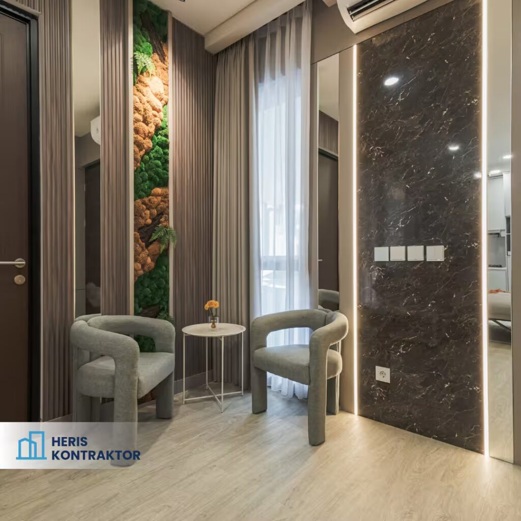 Sudut ruang keluarga dengan dua kursi abu melingkar, meja kecil, dan dekorasi dinding marble serta vertical garden.