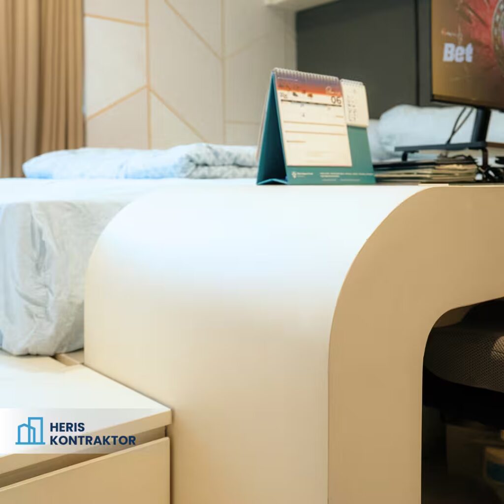 Meja sudut interior apartemen dengan desain melengkung dan material putih doff yang elegan.