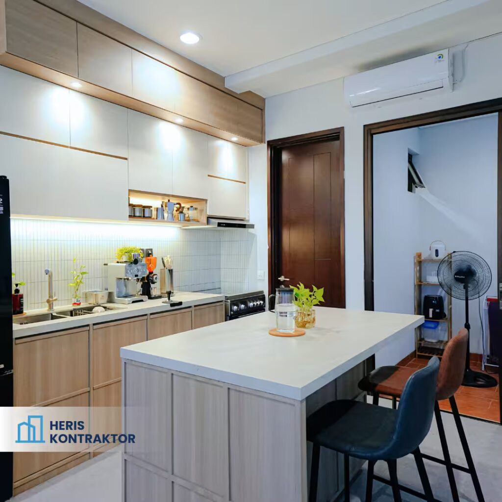 Dapur minimalis dengan meja island besar dan kombinasi kabinet kayu serta putih.