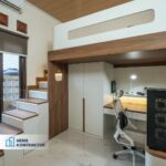 Pandangan menyeluruh kamar anak loft modern dengan tangga laci berlampu LED, lemari putih built-in, meja belajar dan gaming L-shape berlampu, kursi gaming, dan PC tower di sudut
